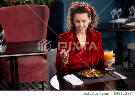 Elegant young woman eating shrimp salad for lunch in luxury hotel restaurant, Healthy lifestyle and diet concept 84511287