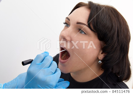 Doctor in a protective suit taking a throat and nasal swab from a patient to test for possible coronavirus or covid infection Doctor in a protective suit taking a throat and nasal swab from a patient to test for possible coronavirus or covid infection 84511476
