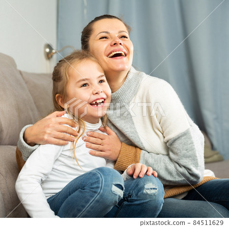 Happy family woman with small daughter laughing at home Happy family woman with small daughter laughing at home 84511629