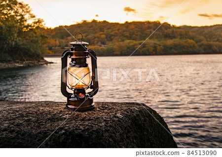 黃昏時在湖岸上燃燒著柔和火焰的油燈 黃昏時在湖岸上燃燒著柔和火焰的油燈 84513090