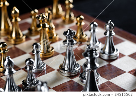 Gold and silver chess figures placed on chessboard 84515562
