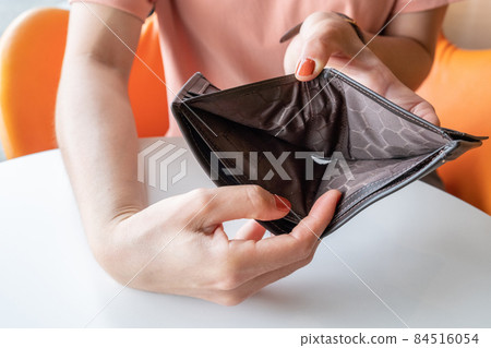 Close-up of woman hands open an empty wallet, Bad economics situation. Conceptual of unhappy bankrupt woman. 84516054