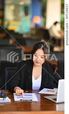 Portrait asian businesswoman analyzing business graph at office desk. Portrait asian businesswoman analyzing business graph at office desk. 84516657