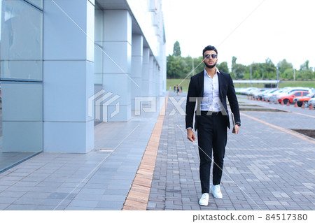 Arabic guy in business center stands smiling walking slow Arabic guy in business center stands smiling walking slow 84517380