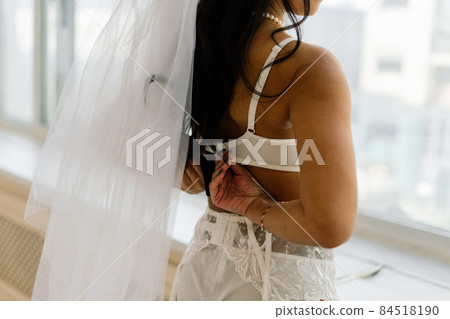 African american bride in lingerie and veil in morning preparing for the wedding in a hotel room African american bride in lingerie and veil in morning preparing for the wedding in a hotel room 84518190