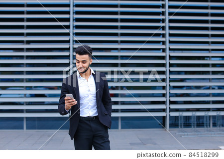 Young arabic man uses mobile smart phone business center Young arabic man uses mobile smart phone business center 84518299