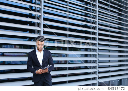 Arabic guy in business center stands smiling Arabic guy in business center stands smiling 84518472