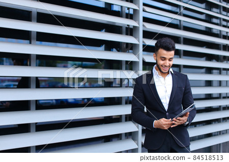 Arabic guy in business center stands smiling Arabic guy in business center stands smiling 84518513