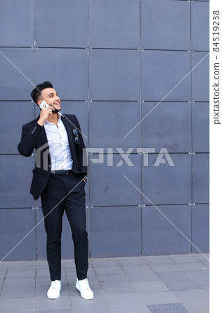 Handsome arabic man talks on smart phone in business center Handsome arabic man talks on smart phone in business center 84519238