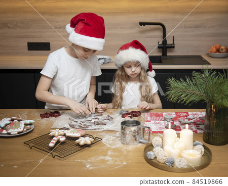 Children - a boy and a girl are preparing gingerbread in the kitchen 84519866