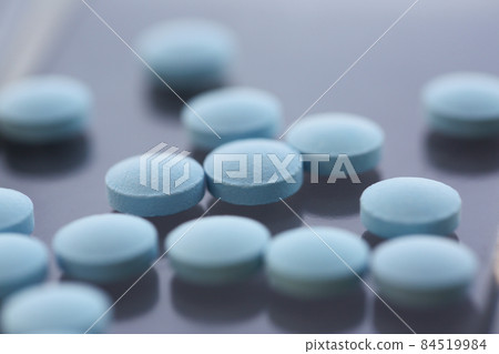 A set of blue pills on the table, close-up, shadow 84519984