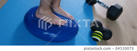 Children feet standing on balancing orthopedic pillow in rehabilitation center closeup Children feet standing on balancing orthopedic pillow in rehabilitation center closeup 84520078