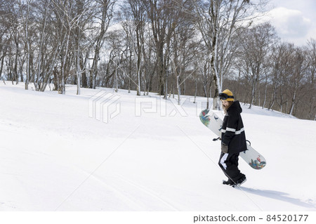 一位年輕女子在滑雪勝地行走,上面有滑雪板的滑雪板圖像 一位年輕女子在滑雪勝地行走,上面有滑雪板的滑雪板圖像 84520177