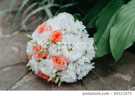 The wedding bouquet of the bride lies on the stone floor. culture, wedding ethical traditions concept. 84521875