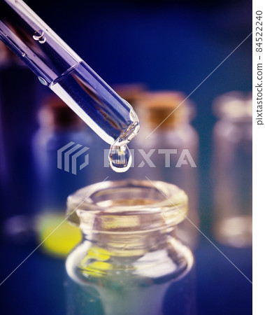 drop of liquid from a pipette into a medical bottle, research concept, new drugs and science, on a bright pink, blue and purple background drop of liquid from a pipette into a medical bottle, research concept, new drugs and science, on a bright pink, blue and purple background 84522240