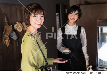 A female photographer who makes a smartphone payment at a cafe "Western confectionery store sentiment" A female photographer who makes a smartphone payment at a cafe "Western confectionery store sentiment" 84523838