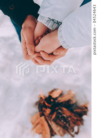 Man warms hands of a woman in his hands. winter hike theme Man warms hands of a woman in his hands. winter hike theme 84524643