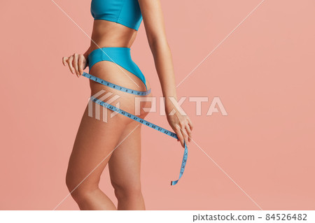 Side view of sportive body of young woman isolated on pink studio background. Natural beauty, anti-cellulite concept Side view of sportive body of young woman isolated on pink studio background. Natural beauty, anti-cellulite concept 84526482