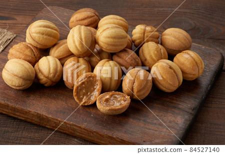 baked dessert nuts with condensed milk on a wooden board, top view 84527140