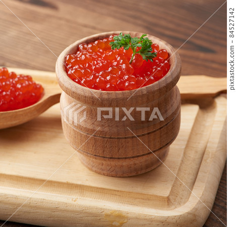 grainy red caviar in a wooden bowl on a brown table grainy red caviar in a wooden bowl on a brown table 84527142