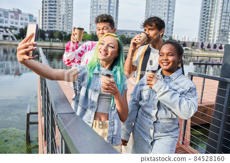 Friends drinking coffee and taking selfie on phone 84528160