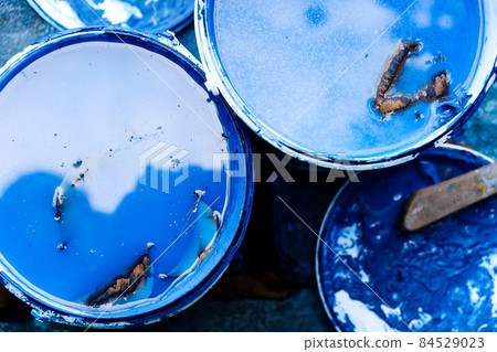 Top view of bucket with blue paint and brush 84529023