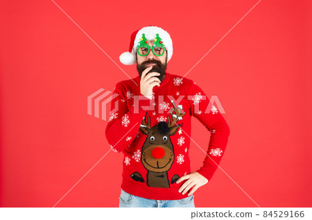 pondering brutal hipster man in santa hat with party glasses on red background, santa pondering brutal hipster man in santa hat with party glasses on red background, santa 84529166