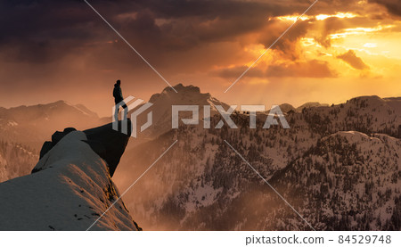 Extreme adventure composite. Man on top of a Rocky Mountain Cliff. 84529748