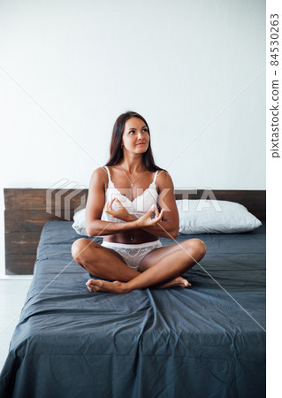 woman in lingerie sitting in the bedroom on the bed 84530263