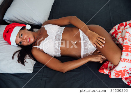 woman in lingerie lies on Christmas bed new year woman in lingerie lies on Christmas bed new year 84530293