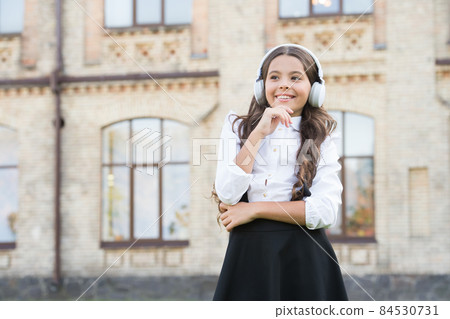 Happy kid outdoors. Cheerful schoolgirl. Schoolgirl  84530731