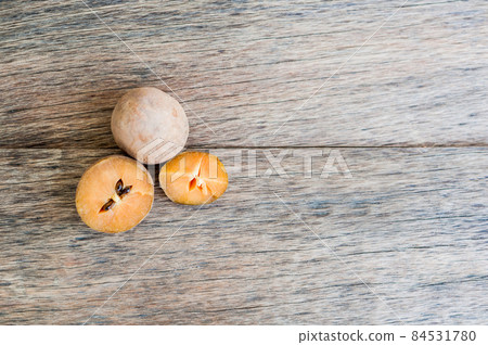 fresh sapodilla fruits on old wooden background fresh sapodilla fruits on old wooden background 84531780