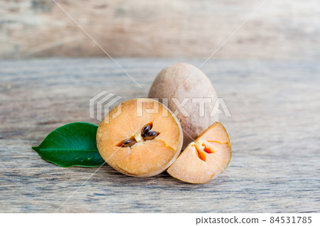 fresh sapodilla fruits on old wooden background 84531785