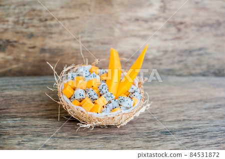 Fruit salad with dragon fruit and papaya in half a coconut 84531872