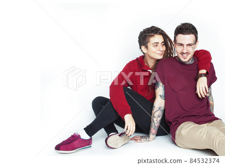 Young couple together. guy with tattoo, girlfriend wearing dreadlocks having fun on white background Young couple together. guy with tattoo, girlfriend wearing dreadlocks having fun on white background 84532374