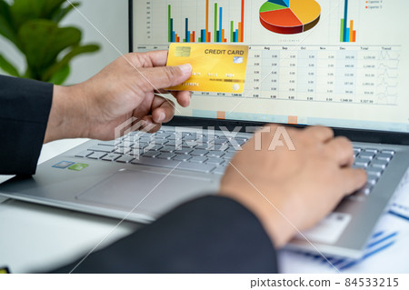 Asian accountant working, calculate and analyzing report project accounting with notebook and credit card in modern office, finance and business concept. 84533215