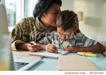 Black mother kissing son in head while they play Black mother kissing son in head while they play 84534189