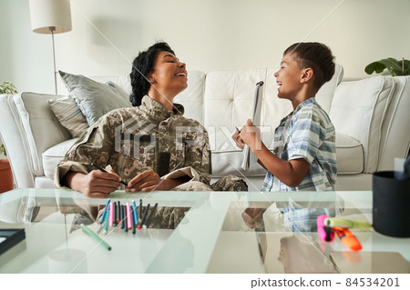 Black boy shows picture in notebook to his mother Black boy shows picture in notebook to his mother 84534201