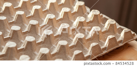 Protective cardboard packaging for storing eggs. Empty biodegradable molded egg box made of paper pulp.  84534528