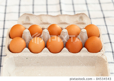 A few brown eggs among the cells of a large cardboard bag, a chicken egg as a valuable nutritious product, a tray for carrying and storing fragile eggs. A full package of eggs, an important food item A few brown eggs among the cells of a large cardboard bag, a chicken egg as a valuable nutritious product, a tray for carrying and storing fragile eggs. A full package of eggs, an important food item 84534543
