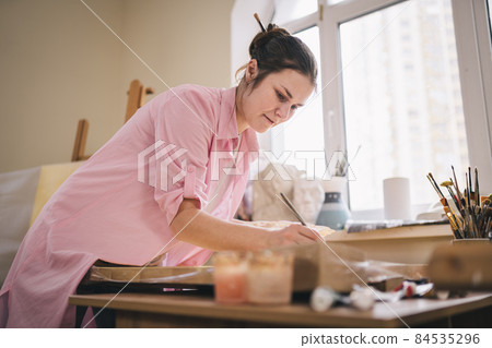 Female artist working in studio. Creative workspace, painting class, easel with canvas, art therapy. Inspiration, creativity, talent, craft concept. Artist studio interior. People, leisure and hobby 84535296