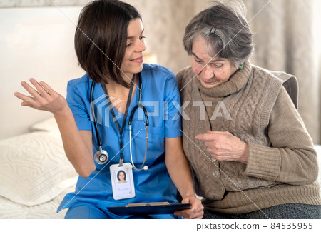 Young nurse is caring for an elderly 80-year-old woman at home,  84535955