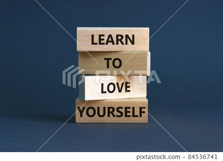 Learn to love yourself symbol. Concept words 'Learn to love yourself ' on wooden blocks on a beautiful grey background. Businessman hand. Business, psychological and learn to love yourself concept. 84536741