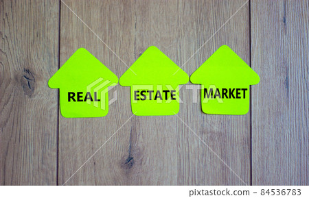 Colored paper houses with words 'real estate market' Beautiful wooden background. Business concept, copy space. 84536783