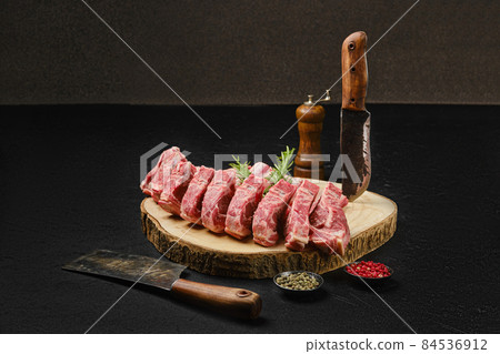 Raw lamb rib roast on wooden slab Raw lamb rib roast on wooden slab 84536912