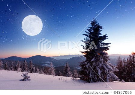 Winter mountains landscape. Night landscape with stars on sky. Amazing view at mountains and sky full of stars at night. Beautiful winter night in mountains. High quality photo 84537096