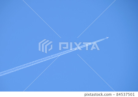 Distant passenger jet plane flying on high altitude on clear blue sky leaving white smoke trace of contrail behind. Air transportation concept. Distant passenger jet plane flying on high altitude on clear blue sky leaving white smoke trace of contrail behind. Air transportation concept. 84537501