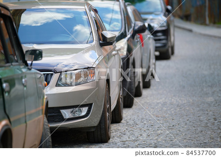 City traffic with cars parked in line on street side. City traffic with cars parked in line on street side. 84537700