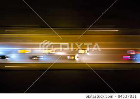 Aerial view of road with fast moving heavy traffic at night. Top view of urban transportation. Rush hour with motion blurr car trail lights Aerial view of road with fast moving heavy traffic at night. Top view of urban transportation. Rush hour with motion blurr car trail lights 84537811
