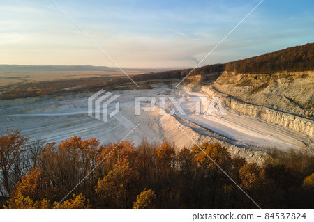 Aerial view of open pit mine of sandstone materials for construction industry with excavators and dump trucks. Heavy equipment in mining and production of useful minerals concept Aerial view of open pit mine of sandstone materials for construction industry with excavators and dump trucks. Heavy equipment in mining and production of useful minerals concept 84537824